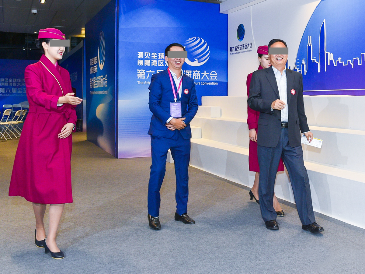 會議禮儀人員微笑著引導(dǎo)嘉賓入場